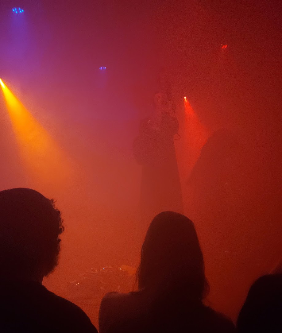 a member of sunn holding his guitar up